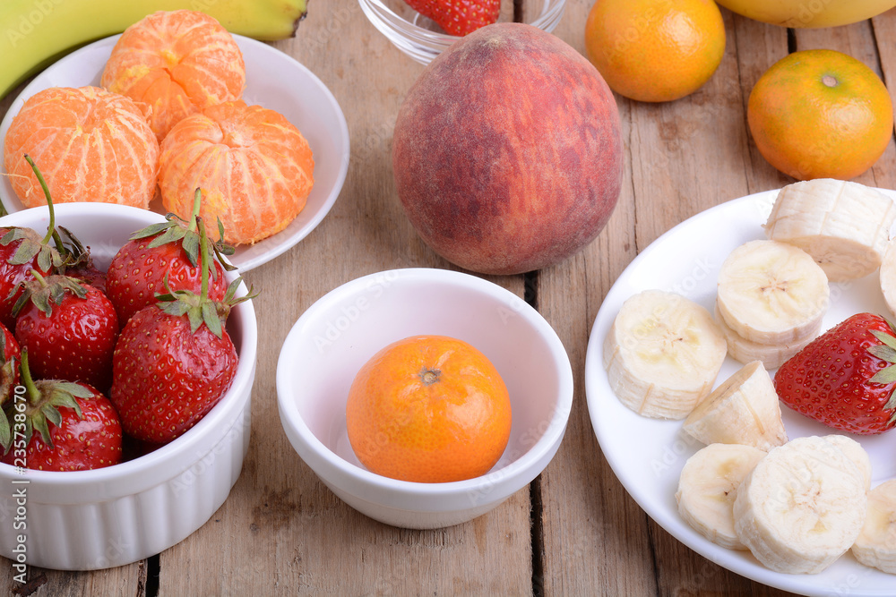 Close-up shot of variety of fruits on old wooden plate Close-up shot of variety of fruits on old wooden plate