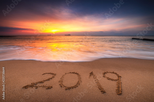 Happy New Year 2019 concept, lettering on the beach. Sea sunrise