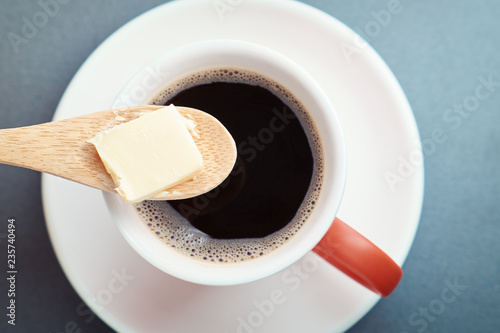 Bulletproof coffee, cup and butter in spoon photo