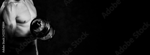Photography close up of muscular man doing exercises with dumbbell over grey background