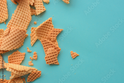 Crushed ice cream waffle cones on pastel blue background