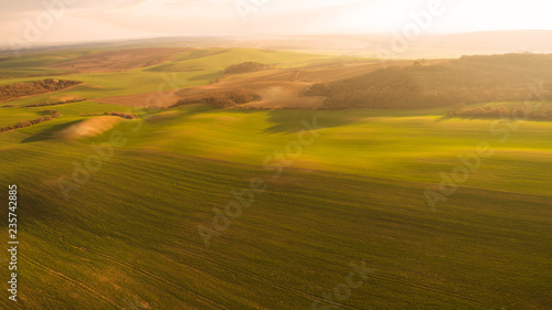Fototapeta Naklejka Na Ścianę i Meble -  Aerial landscape with green field, sunset light