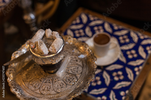 Hookah with coconut charcoal for relax and shisha smoke. Hot coals with hookah sparks in metal bowl for Smoking and traditional Asian relaxation close up. hookah and coffee from the top close up view