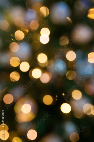 Defocused Christmas tree and garlands, yellow bokeh