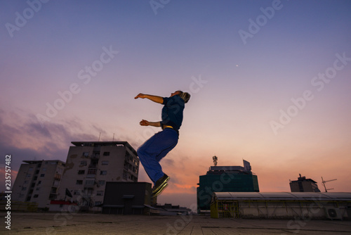 Acrobat man outdoors practicing parkour