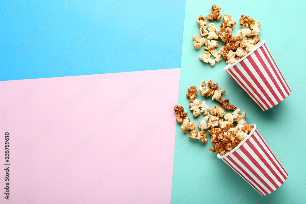 Caramel popcorn in paper cups on colorful background