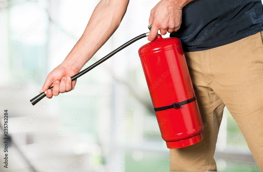 Naklejka premium Hand presses the trigger fire extinguisher hand presses the