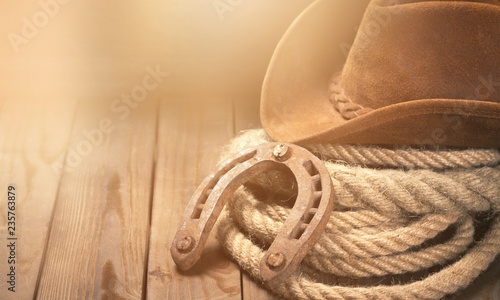 Canvas Print Old horseshoe , lariat lasso and cowboy hat on background