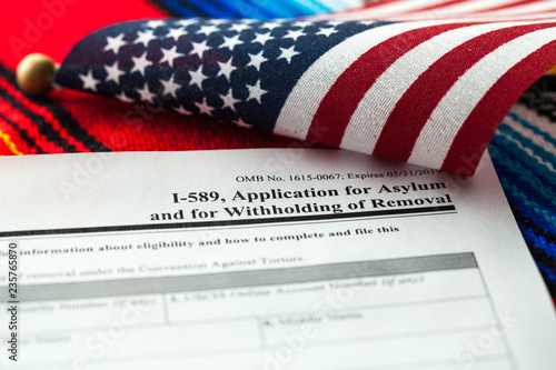 Application for asylum to USA concept with application form and USA flag on mexican serape