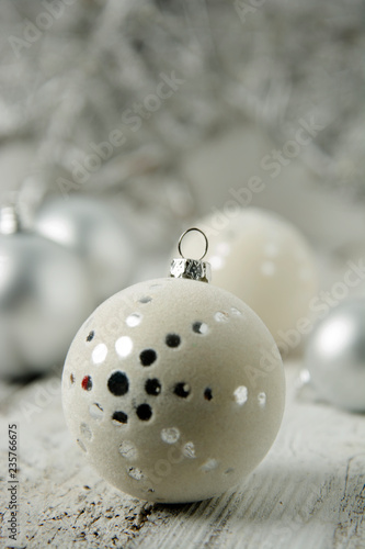 Christmas white background with silver decorative balls or baubles on rustic wooden background.