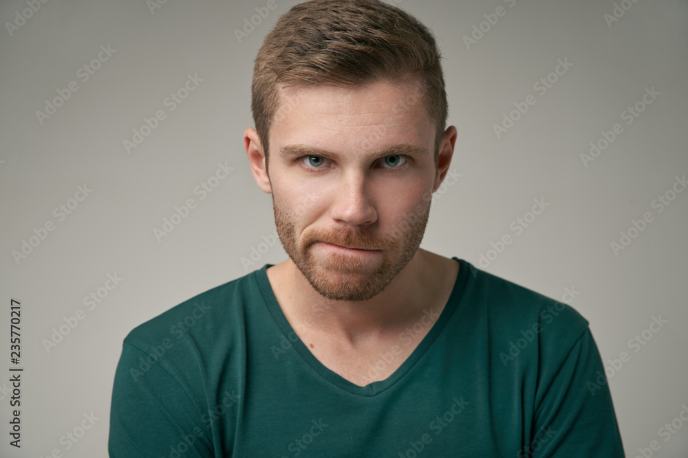 Φωτογραφία A large portrait of a man curves his mouth on a gray background