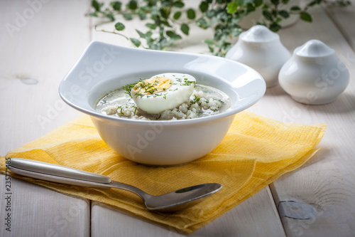 Sorrel soup with egg in white bowl.