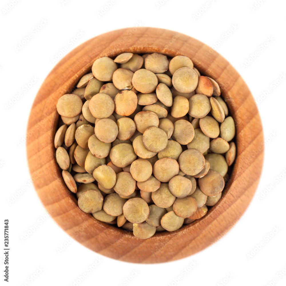 dry lentils on wooden bowl isolated on a white background dry lentils on wooden bowl isolated on a white background