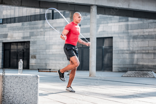 Canvas Print Hard working athletic man jumping on a skipping rope