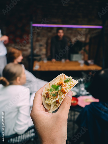 Tacos with chicken and crumbs in man hand
