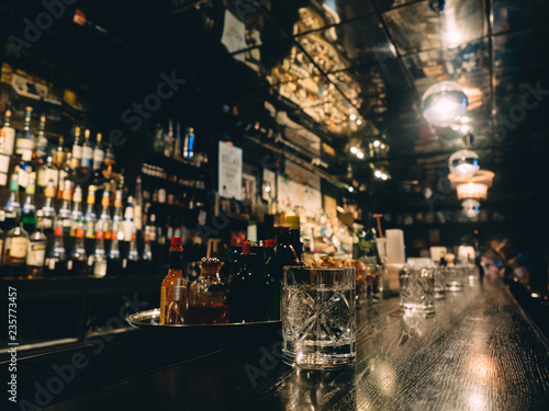 Bar stand with bottles of alcohol in dark