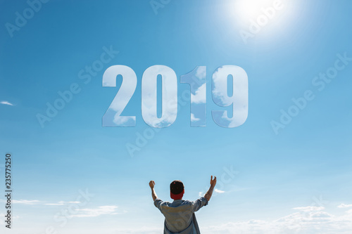 Man, against the blue sky, the guy pulls hands to the sky, the concept of the new 2019 year.