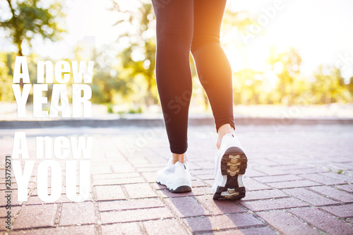 Photo of sports female legs, jogging. Image with text. New year new me. The concept of sport, motivation.