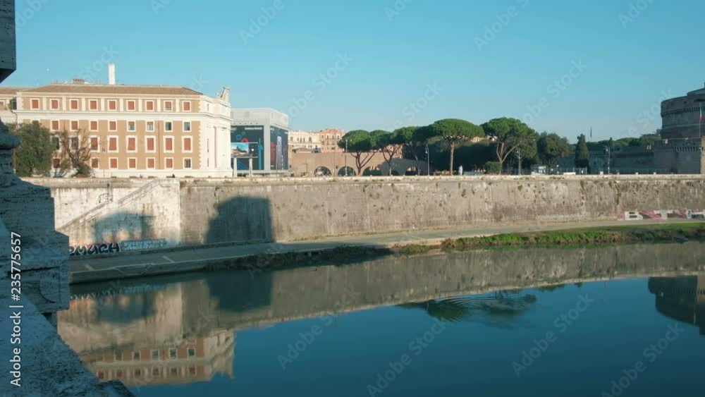 Panning right video reveal of Castel Sant'Angelo and bridge mirror image reflection in the calm Tiber River on a tranquil morning in Rome, Italy. 4K UHD at 29.97fps Panning right video reveal of Castel Sant'Angelo and bridge mirror image reflection in the calm Tiber River on a tranquil morning in Rome, Italy. 4K UHD at 29.97fps