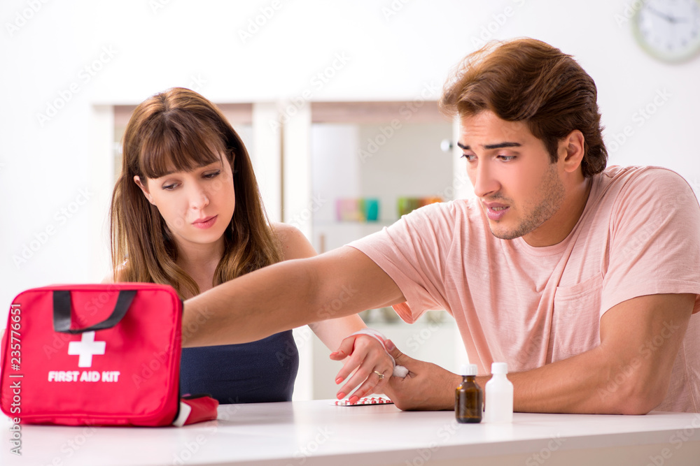 Young family getting treatment with first aid kit Young family getting treatment with first aid kit