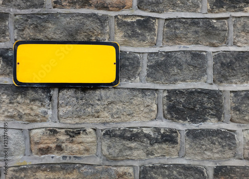 Принти на полотні a blank yellow metal sign with empty space for copy on an old stone wall backgro
