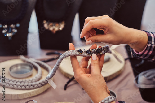Close-up photo of a woman's hands who makes handmade necklaces