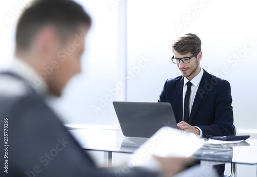 businessman in suit in office using tablet