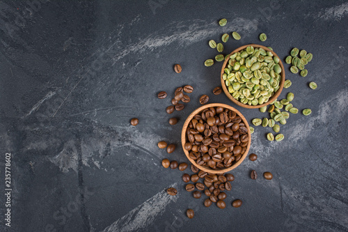 Top view of raw green and brown roasted coffee beans in wooden bowls