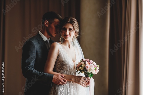 Wedding photo shoot of the newlyweds in a dark hotel room.