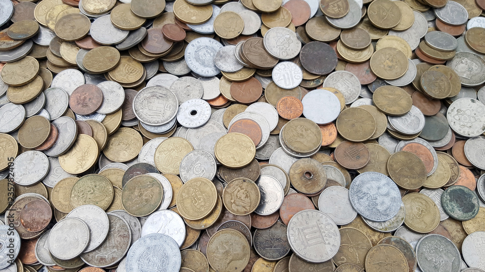 A pile of old coins from different currencies and materials A pile of old coins from different currencies and materials
