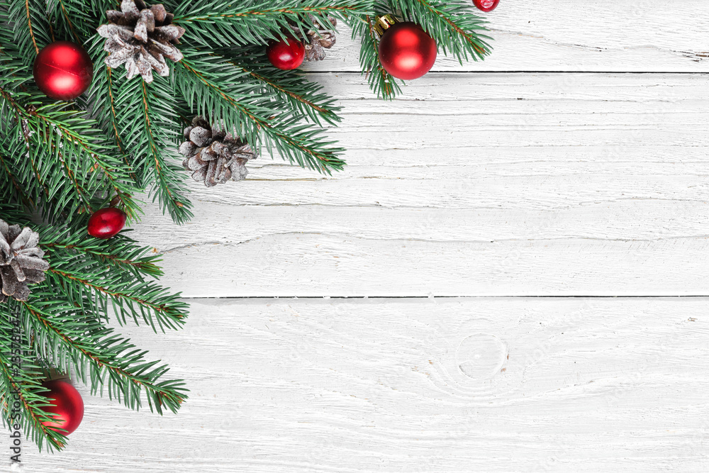 christmas background made of fir branches, decorations, red berries and pine cones on white wooden table christmas background made of fir branches, decorations, red berries and pine cones on white wooden table