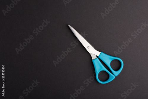 Blue Scissors on black background, Closed Scissors, top view.