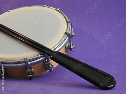 Tamborim and drumstick: a small, round Brazilian frame drum. It is widely used to accompany samba. It has great prominence in the parades of samba schools, in the Brazilian carnival.