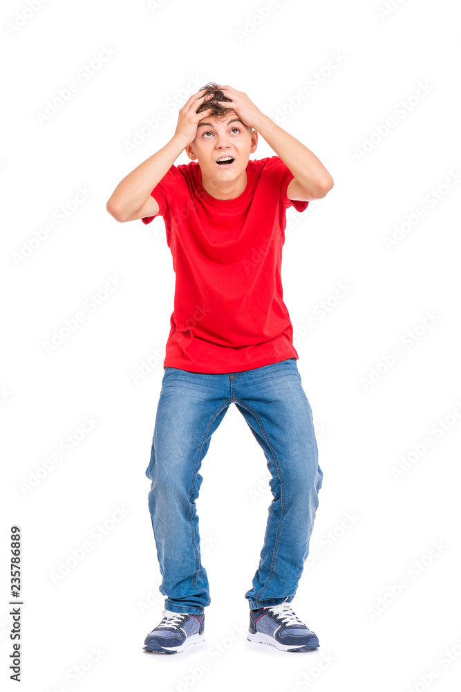 Cute child covered his head with his hands. Full length portrait of caucasian teen boy wearing red t-shirt. Funny teenager is afraid something fall on him, isolated on white background Cute child covered his head with his hands. Full length portrait of caucasian teen boy wearing red t-shirt. Funny teenager is afraid something fall on him, isolated on white background