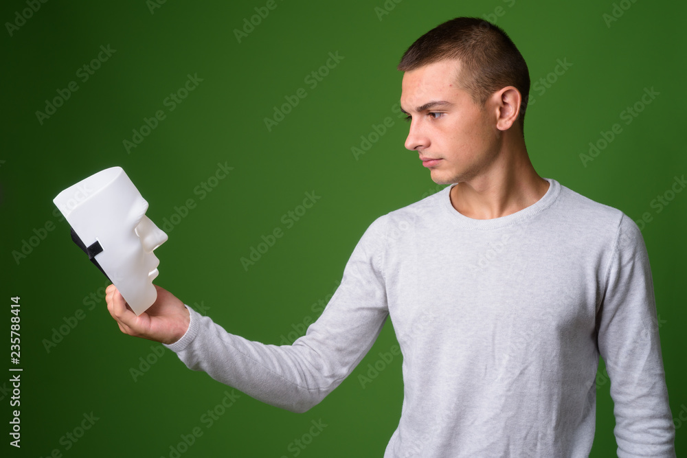 Studio shot of young handsome man against green background Studio shot of young handsome man against green background