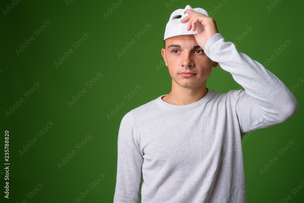 Studio shot of young handsome man against green background Studio shot of young handsome man against green background