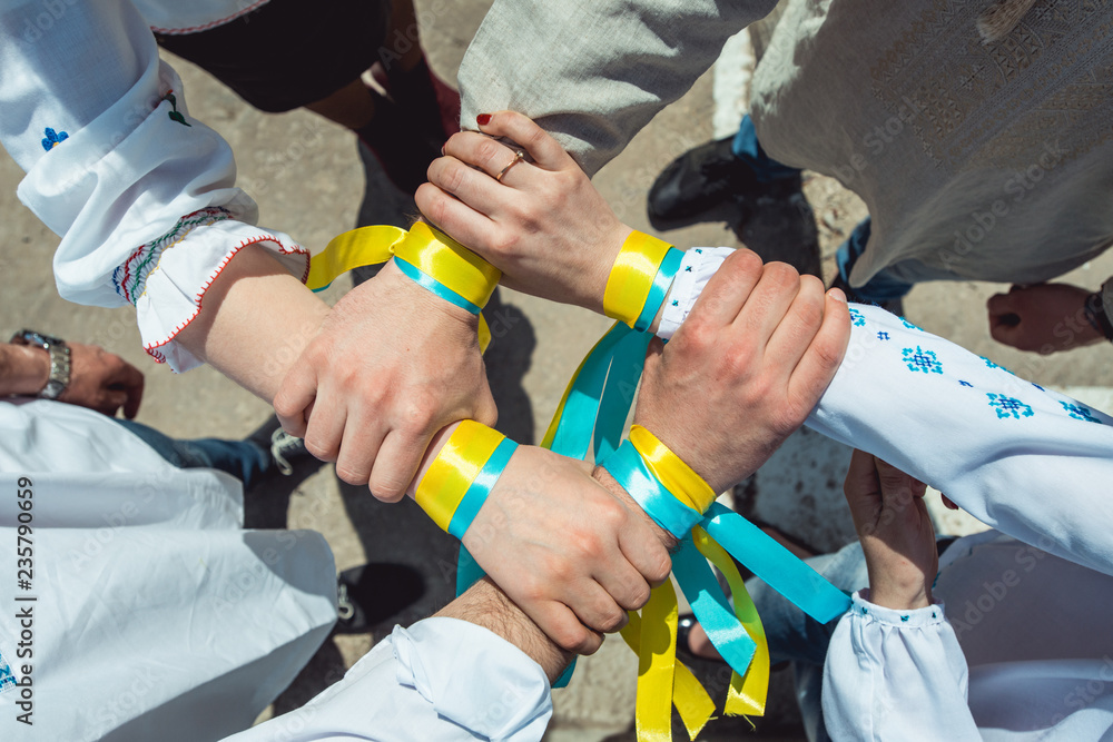 people are dressed in traditional Ukrainian clothes holding their hands together, success unification of the nation concept people are dressed in traditional Ukrainian clothes holding their hands together, success unification of the nation concept