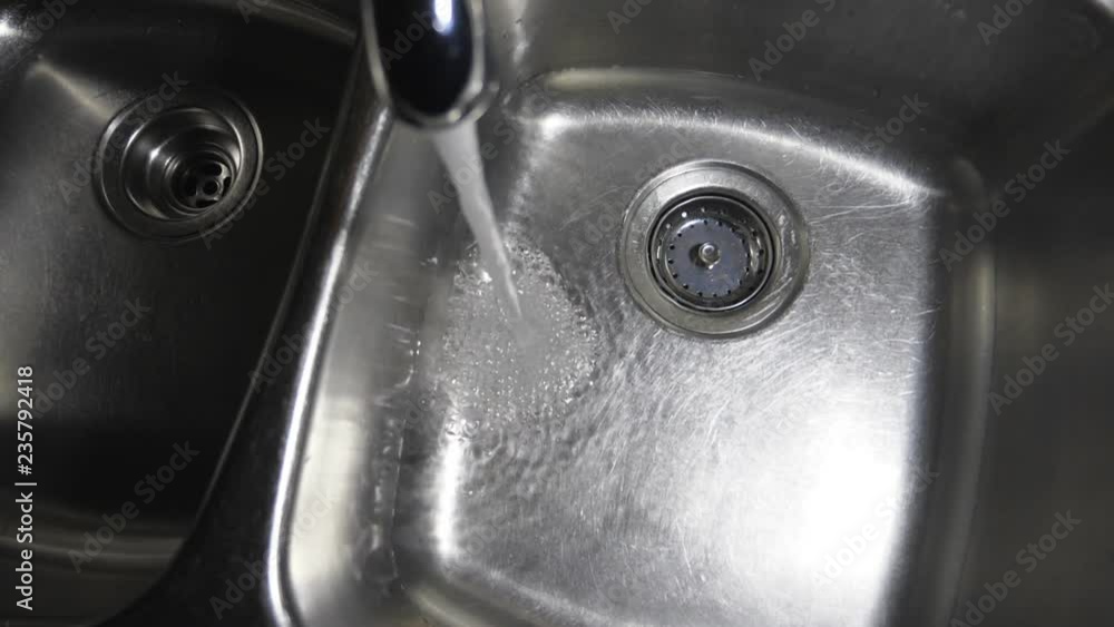 Slow motion kitchen sink filling with water. Overhead shot. Note the