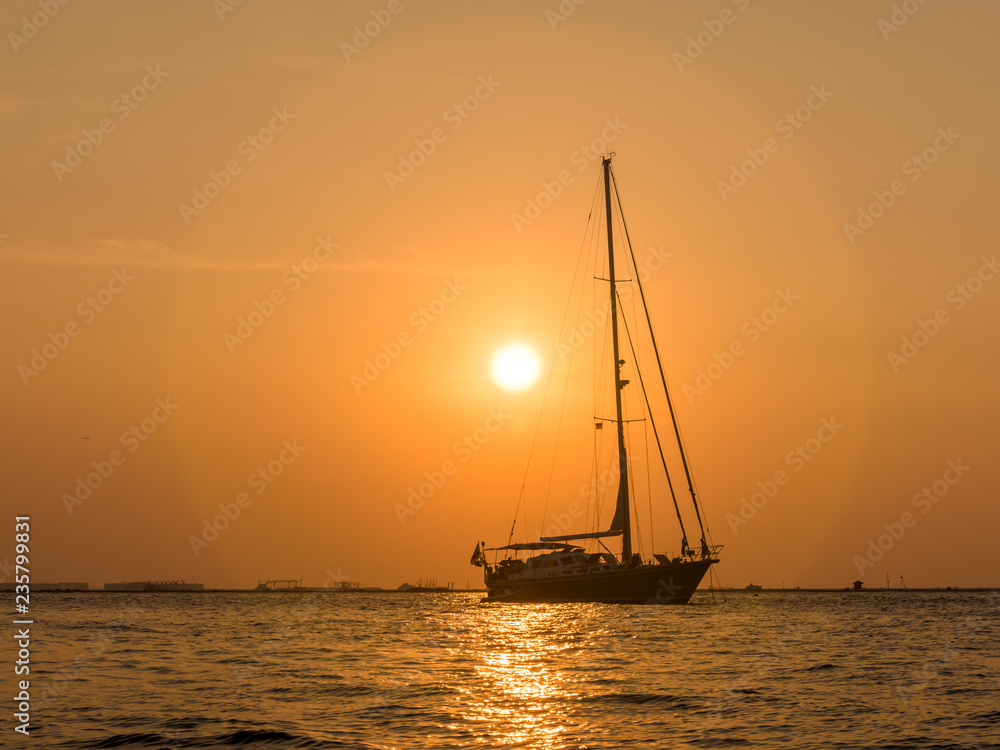 A boat silhouette against sunset sky at Mutiara Beach