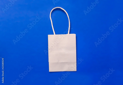 White plain shipping bag on blue background, shopping concept.