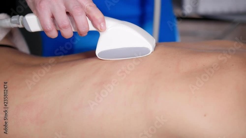 Close up of professional masseur massaging client s back and shoulders with special tool. Relaxing massage photo