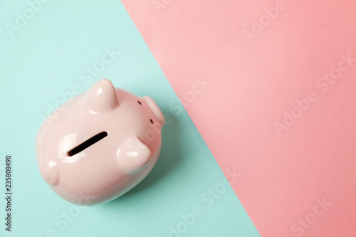 Pink piggy bank isolated on blue and pink pastel colorful trendy geometric background. Saving investment budget wealth business retirement financial money banking concept. Flat lay top view copy space