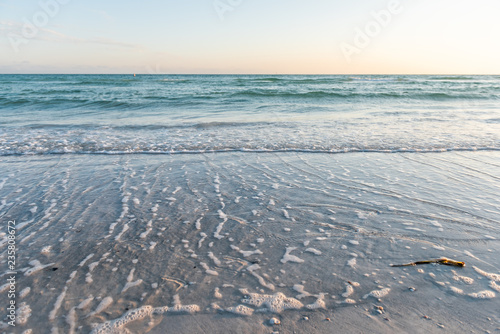 Wave crashing with horizon on shore in Siesta Key  Sarasota  Florida during evening sunset with water  wet sand  nobody