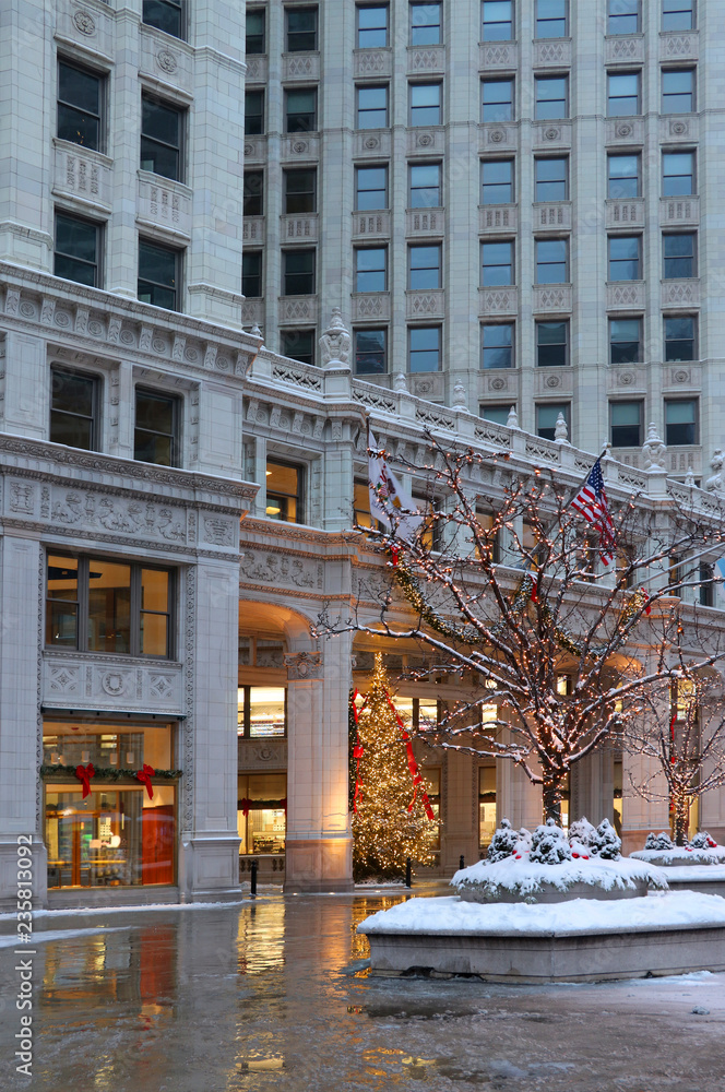 Beautiful Christmas eve in Chicago downtown. Snowy winter day in Chicago downtown. Scenic view in a downtown with street decoration covered by fresh snow in a building background. 