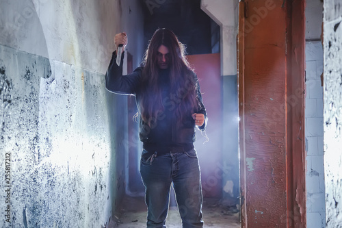 Tableau sur toile Serial killer maniac with knife in dark abandoned building