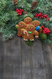 Ginger men cookies with christmas tree branches on wooden background
