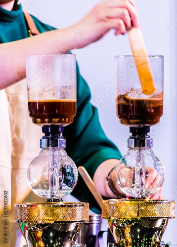 Showcase Syphon Coffee maker by syphonist./ Syphon Coffee or Vacuum Coffee is full immersion tasteful, this process show mix coffee beans into boiling water. photo