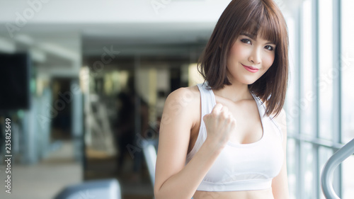 Free Download healthy strong fitness woman working out in gym. portrait of fitness woman in gym posing for strong body, gym workout, fitness people, healthy lifestyle concept. asian adult fitness woman model - GFXLoad
