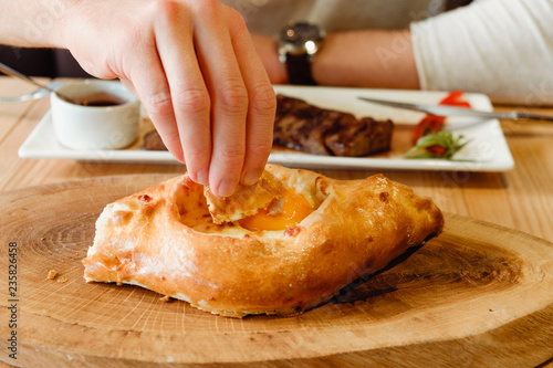 Man eating traditional meat and bread in georgian restaurant photo