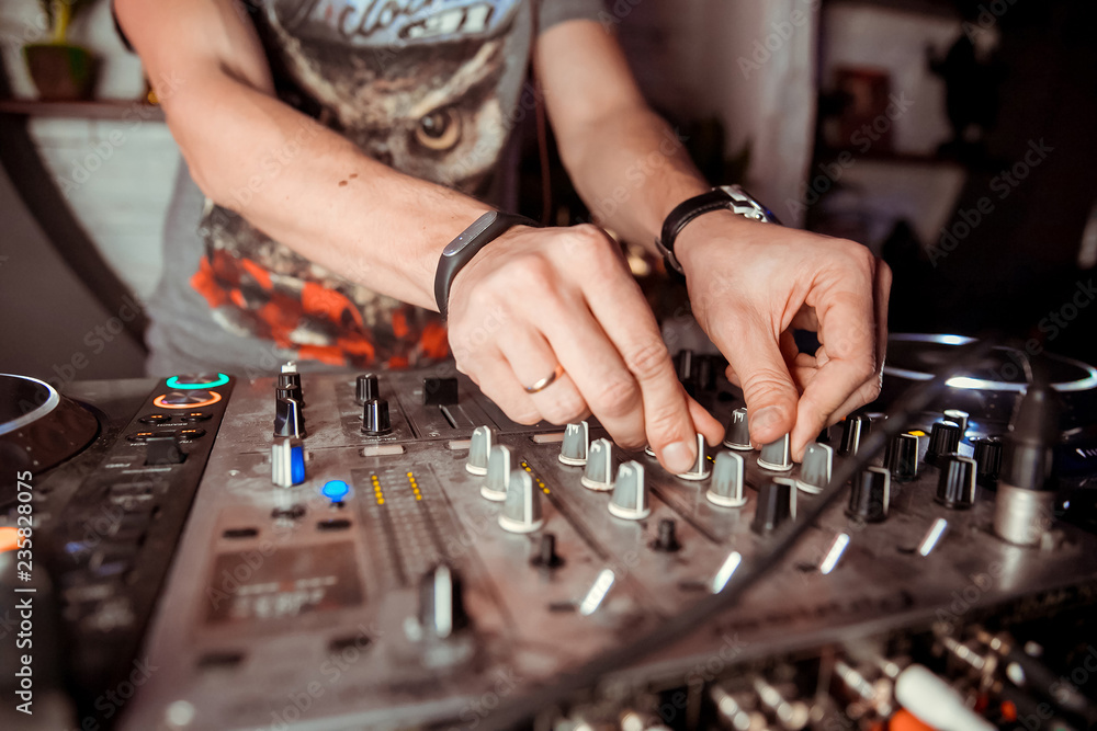 DJ mixer on the table background the night club and dancing people